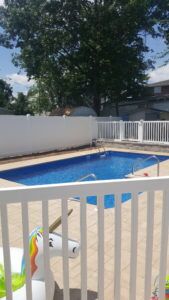 White vinyl fence around in-ground pool