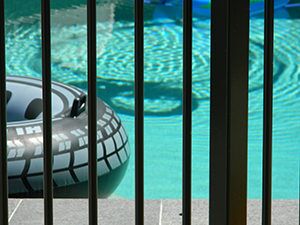 A swimming pool behind a safety fence