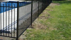 A black aluminu fence encloses a pool on a residential property.